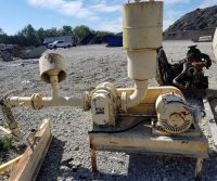 Old industrial machinery on gravel lot.