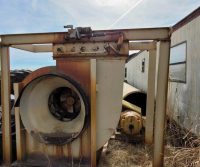 Rusty industrial equipment beside trailer.