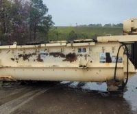 Large industrial machine lying on wet ground.