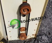 Rusty pulleys on industrial equipment panel.