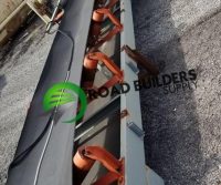 Conveyor belt on gravel surface, outdoor setting.