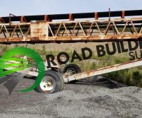 Conveyor belt system on gravel surface.
