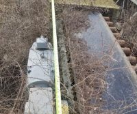 Overgrown machine with measuring tape on top.