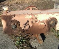 Rusty metal machinery on concrete ground.