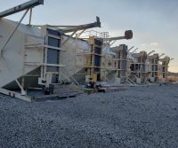 Industrial machinery lying on gravel surface outdoors.
