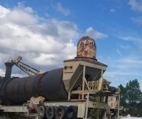 Rusty industrial machinery under cloudy sky.
