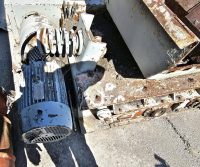 Old rusted industrial machinery on concrete ground.