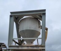 Large industrial hopper under cloudy sky.
