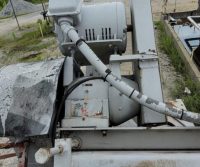 Industrial machinery with motor outdoors, overcast sky.