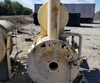 Rusted industrial equipment on gravel surface outdoors.