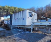 Terex machinery in a wooded industrial area.