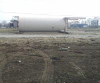 Large industrial tank on grassy field.