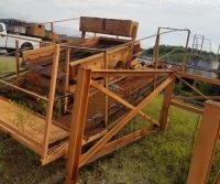 Rusty industrial machinery on grassy field.