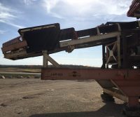Industrial conveyor belt under a clear sky.