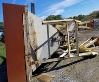 Rusty industrial equipment lying on gravel ground.