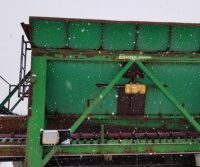 Green industrial machinery in snowy weather.