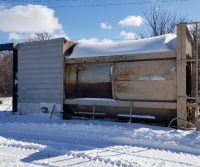 Snow-covered industrial equipment in winter landscape.