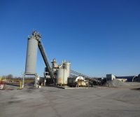 Industrial plant with silos under clear sky.