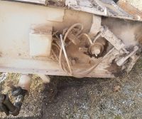 Dirty industrial machinery with exposed cables and components.