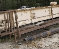 Old industrial container in a dirt yard.