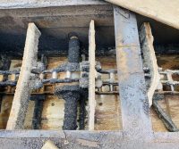 Industrial machinery with chains and wooden panels.