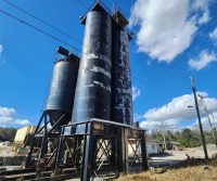 Tall industrial silos under a blue sky.